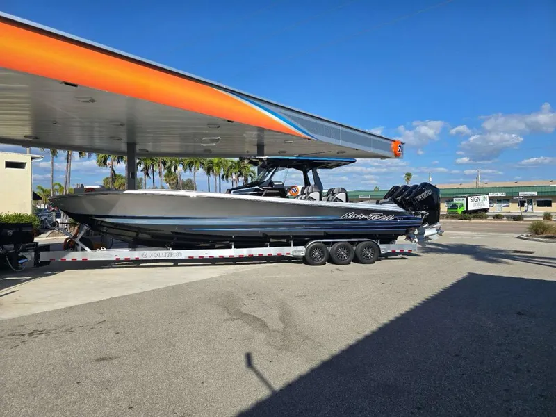 The Image of 2025 Nor-Tech 400SS boat on trailer at gas station under clear blue sky. - 1