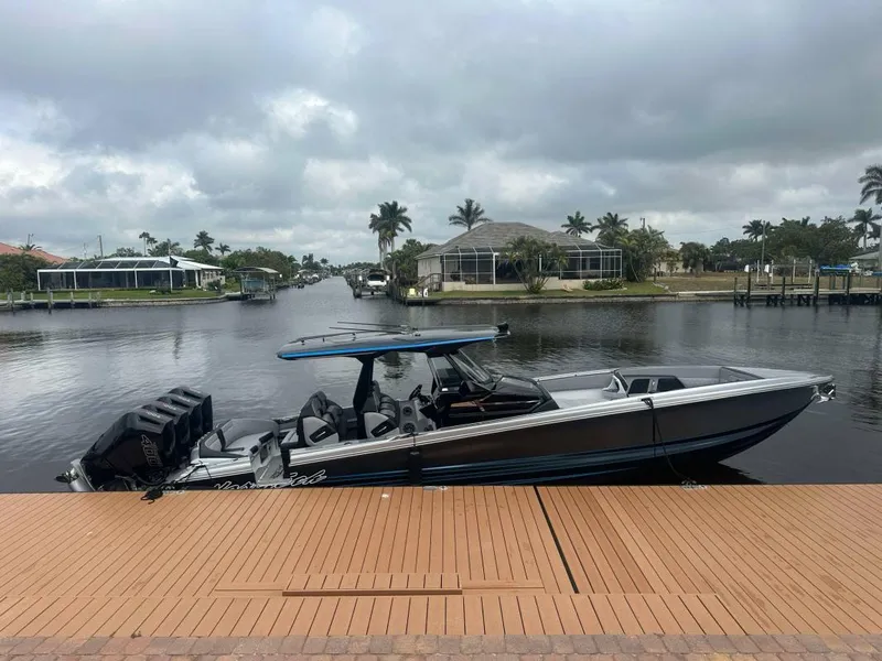 Slide: The Image of 2025 Nor-Tech 400SS boat docked by a scenic waterfront under cloudy skies. - 3