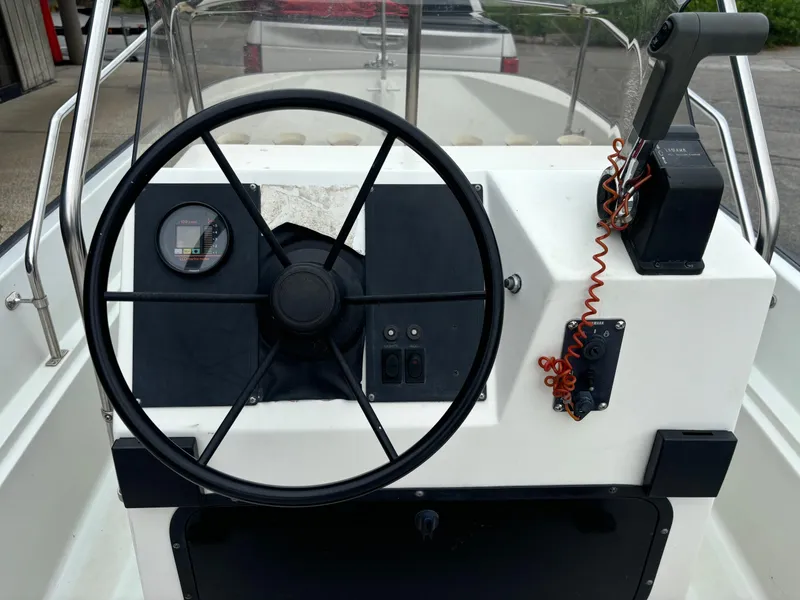 Slide: The Image of 1993 Boston Whaler 17 Montauk boat console with steering wheel and controls. - 11