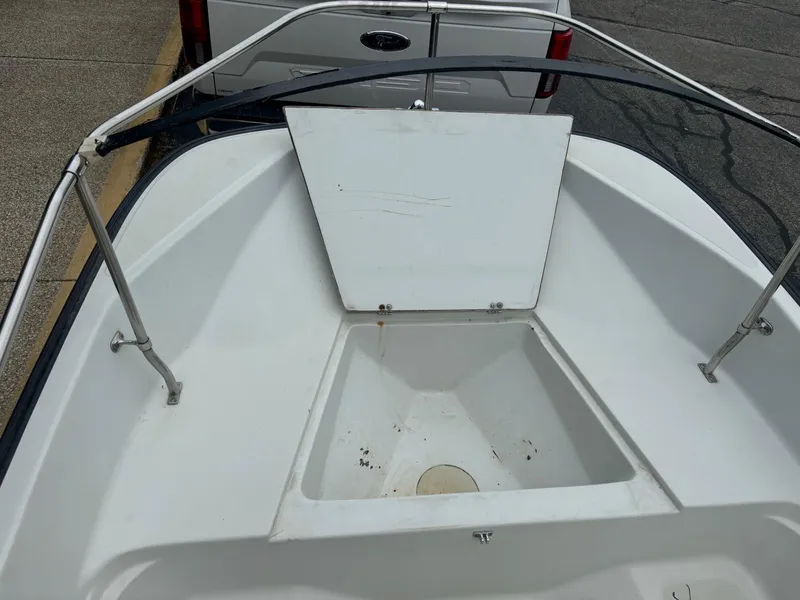 Slide: The Image of 1993 Boston Whaler 17 Montauk boat with open storage compartment and railing. - 9