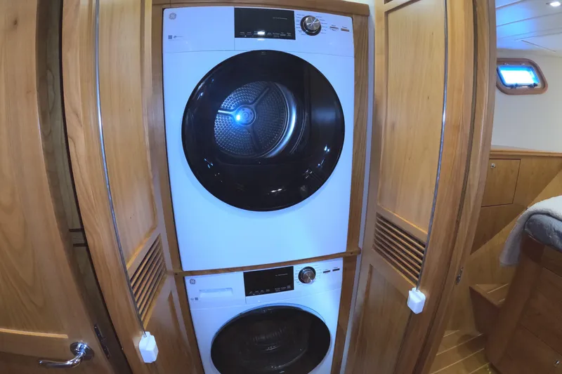 Slide: The Image of Stacked washer and dryer in 2021 Kadey-Krogen 50 Open yacht's wooden interior. - 33