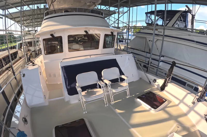 Slide: The Image of 2021 Kadey-Krogen 50 Open yacht deck with chairs under covered marina. - 37