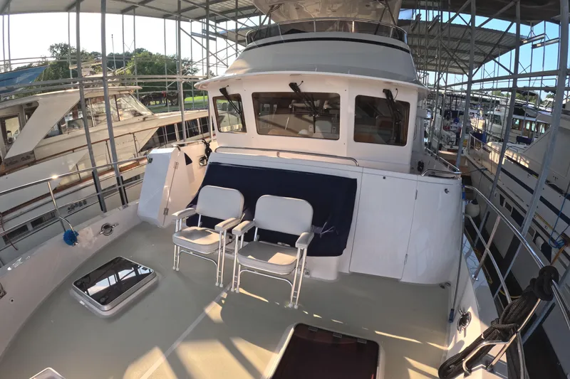 Slide: The Image of 2021 Kadey-Krogen 50 Open yacht deck with seating under covered marina. - 38