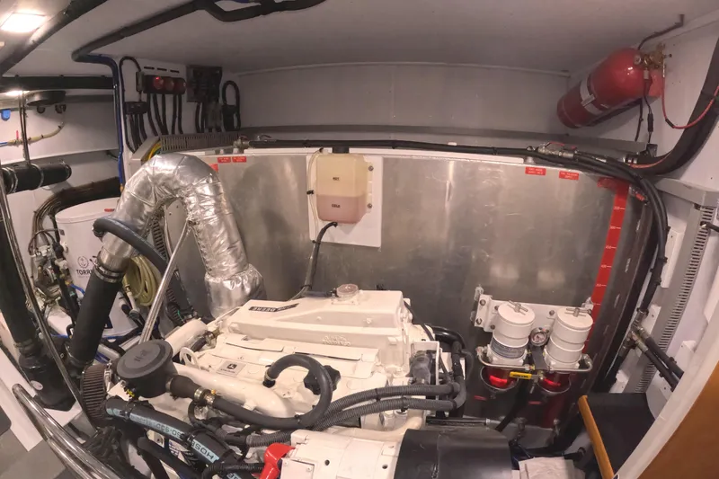 Slide: The Image of Engine room of 2021 Kadey-Krogen 50 Open yacht, featuring mechanical components and fire extinguisher. - 47