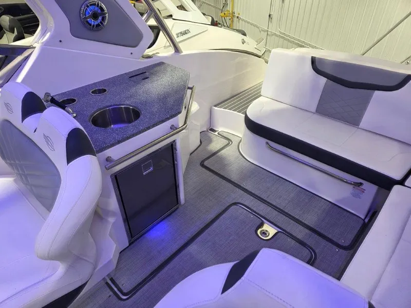Slide: The Image of 2022 Chaparral 347 SSX boat interior with seating, kitchenette, and ambient lighting. - 16