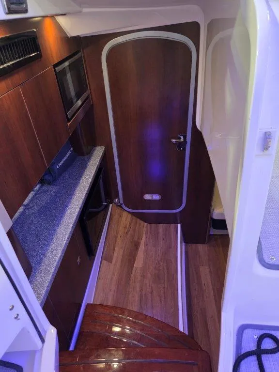 Slide: The Image of 2022 Chaparral 347 SSX cabin interior with wood flooring and kitchenette. - 22