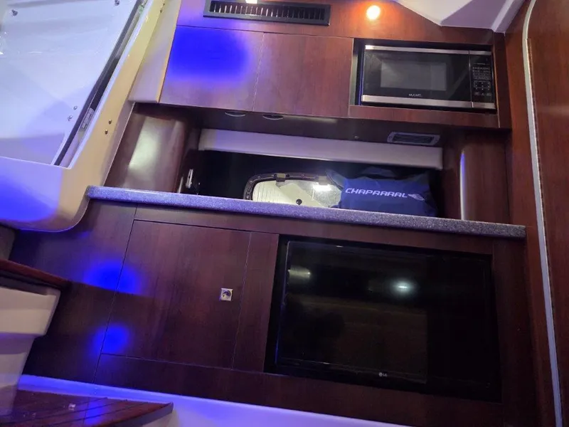 Slide: The Image of 2022 Chaparral 347 SSX interior with microwave, TV, and ambient blue lighting. - 25