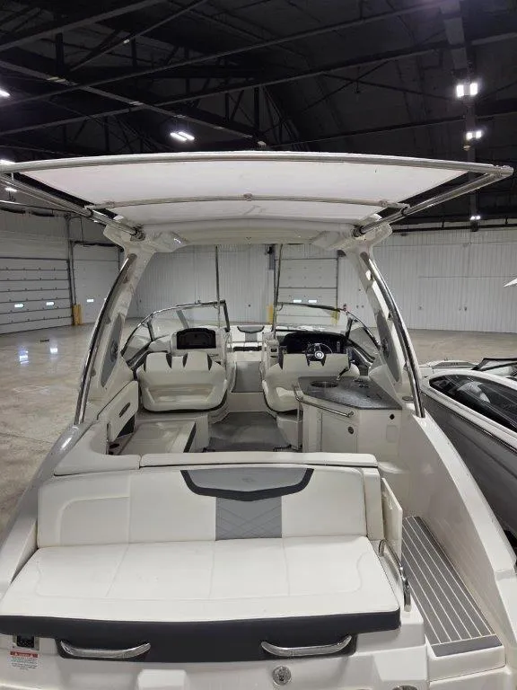 Slide: The Image of 2022 Chaparral 347 SSX boat interior with seating and helm in a warehouse setting. - 33