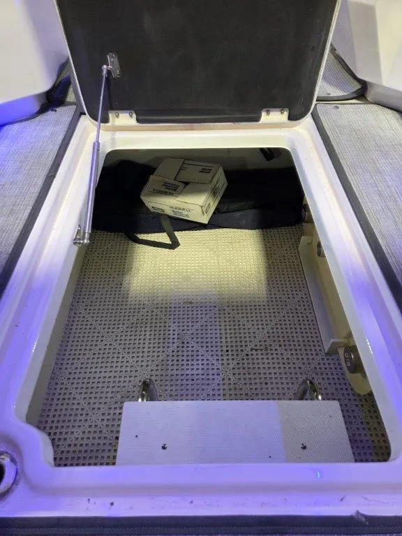 Slide: The Image of Open storage compartment in 2022 Chaparral 347 SSX boat, featuring a box and equipment. - 41