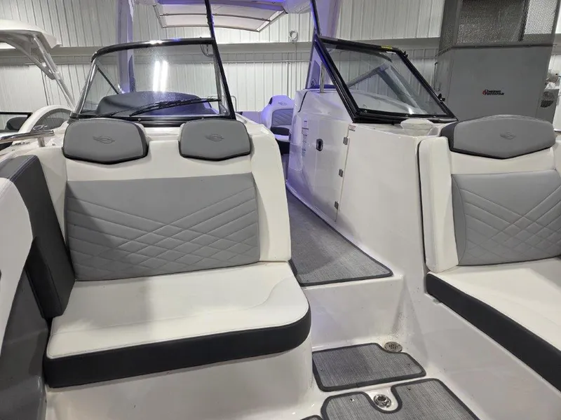 Slide: The Image of 2022 Chaparral 347 SSX boat interior with gray and white seating in a showroom. - 6
