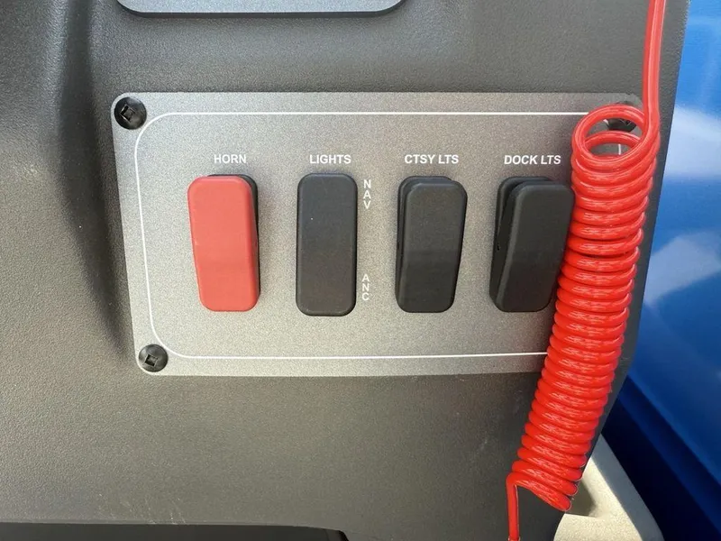Slide: The Image of Control panel of 2026 Sun Tracker PARTY BARGE® 16 DLX with switches and red coiled cord. - 13
