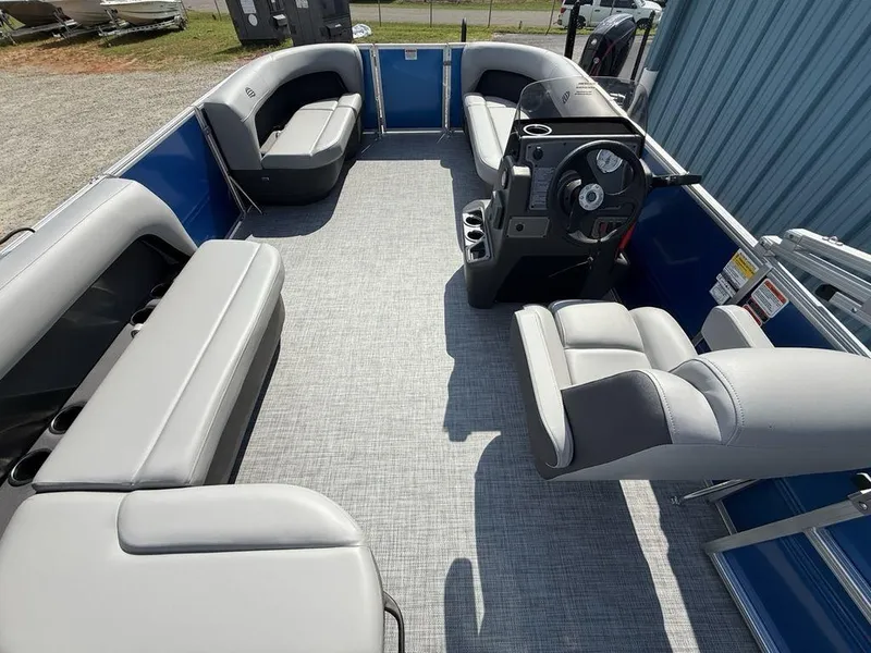 Slide: The Image of 2026 Sun Tracker PARTY BARGE® 16 DLX interior with gray seating and steering console. - 16