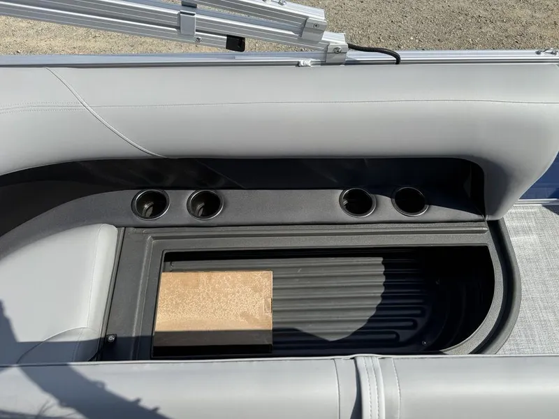 Slide: The Image of 2026 Sun Tracker PARTY BARGE® 16 DLX seating area with cup holders and storage compartment. - 7