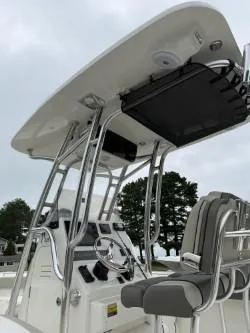 Slide: The Image of 2025 Key West 239 FS boat console with T-top and seating, under cloudy sky. - 5