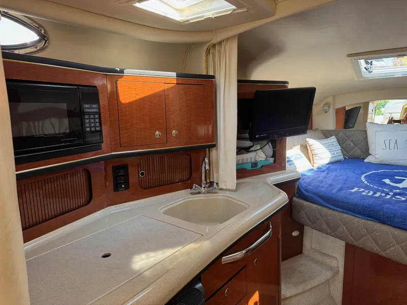 Slide: The Image of Interior of 2002 Sea Ray 300 Sundancer with kitchenette and cozy sleeping area. - 11