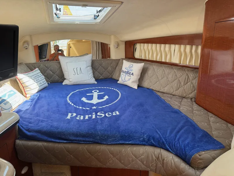 Slide: The Image of Interior of 2002 Sea Ray 300 Sundancer with cozy bedding and nautical decor. - 12