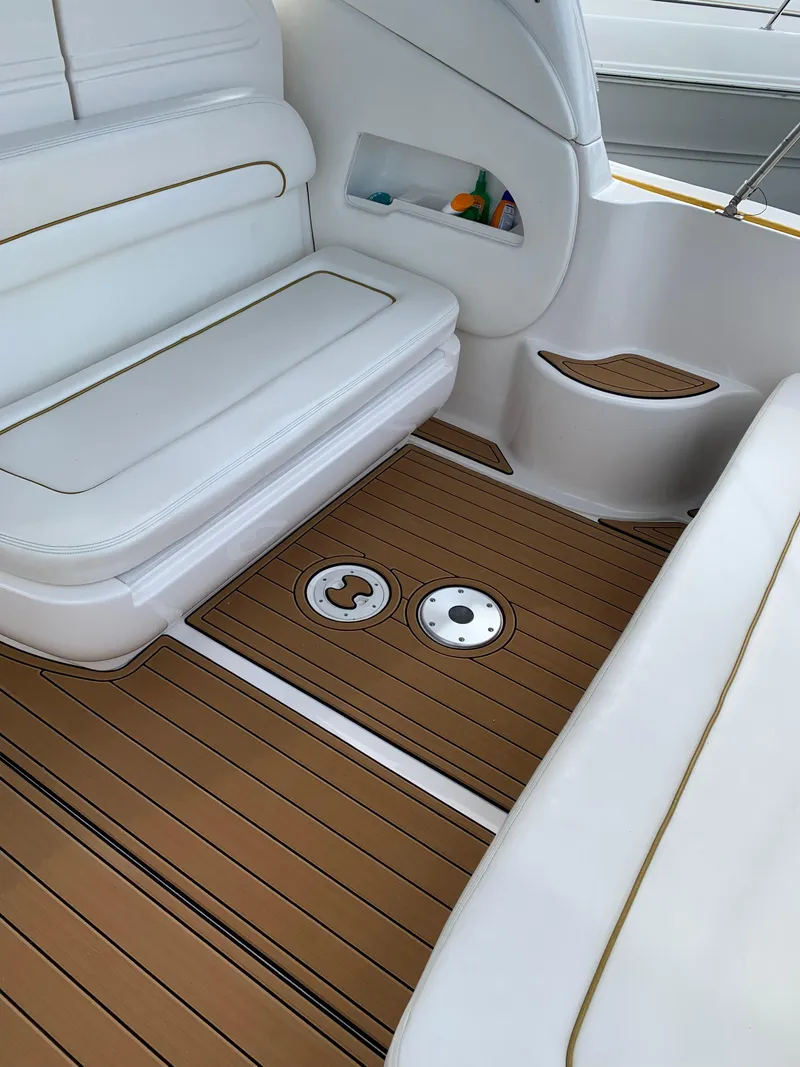 Slide: The Image of Interior of 2002 Sea Ray 300 Sundancer with white seating and teak-style flooring. - 7