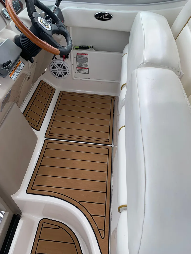 Slide: The Image of Interior of 2002 Sea Ray 300 Sundancer with white seating and wood-accented flooring. - 9