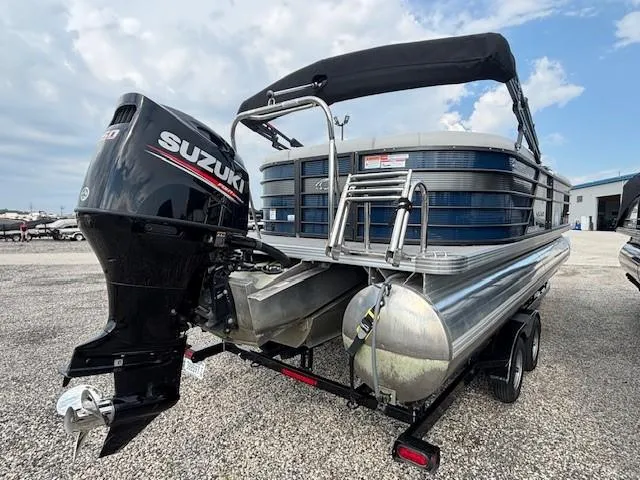 Slide: The Image of 2020 Crest Classic DLX 240 SLC pontoon boat with Suzuki outboard motor, parked on gravel. - 18