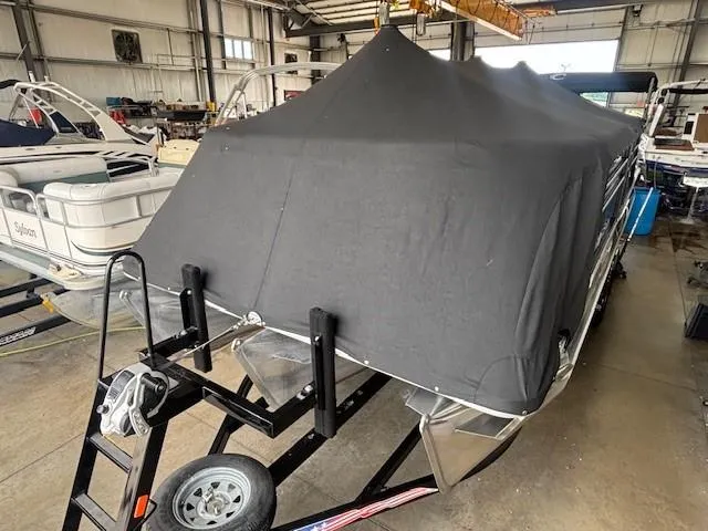Slide: The Image of 2020 Crest Classic DLX 240 SLC boat covered in a black tarp, stored indoors. - 29