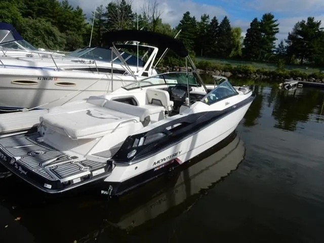 Slide: The Image of 2014 Monterey 288 Super Sport boat docked on calm water, surrounded by trees. - 16