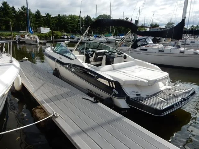 Slide: The Image of 2014 Monterey 288 Super Sport boat docked at marina with sailboats in background. - 20