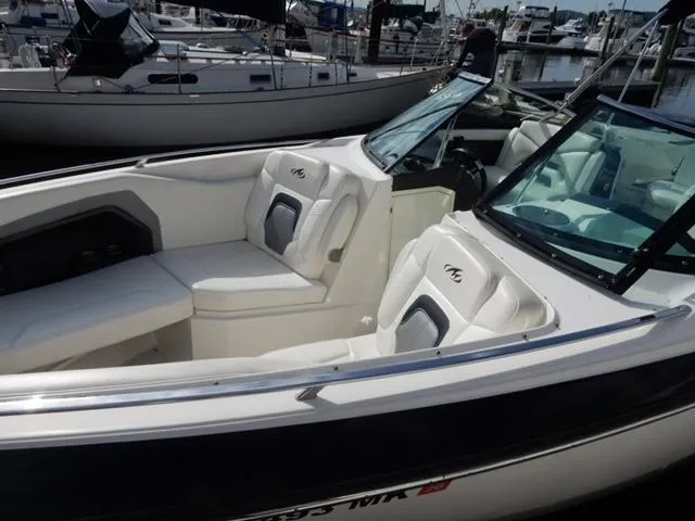 Slide: The Image of 2014 Monterey 288 Super Sport boat with white seating, docked at a marina. - 23