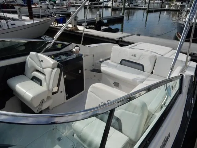 Slide: The Image of 2014 Monterey 288 Super Sport boat interior with white seating at marina. - 25