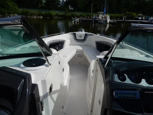 Slide: The Image of 2014 Monterey 288 Super Sport boat interior with open cockpit and dashboard, docked by a marina. - 30