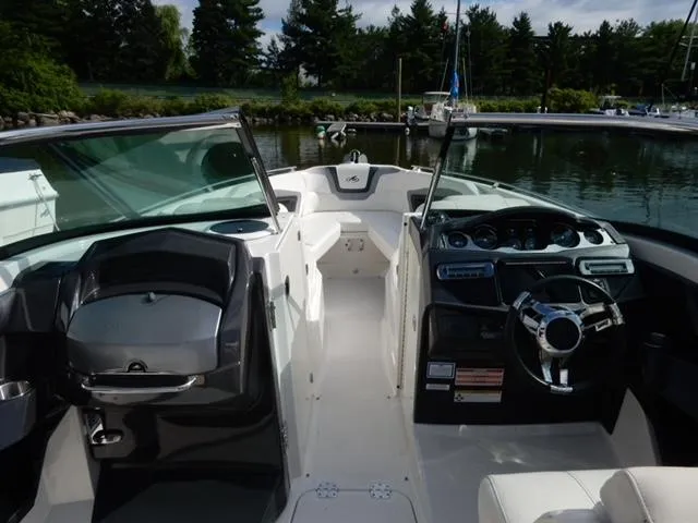 Slide: The Image of 2014 Monterey 288 Super Sport boat interior with sleek dashboard and steering wheel, docked by a marina. - 31