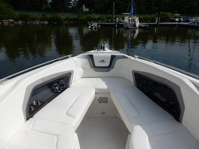 Slide: The Image of 2014 Monterey 288 Super Sport boat interior with white seating, docked on calm water. - 32