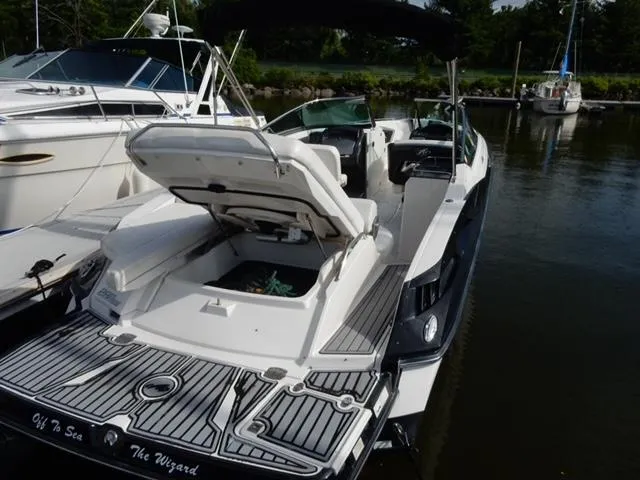 Slide: The Image of 2014 Monterey 288 Super Sport boat docked, open storage, sleek design, calm water setting. - 43