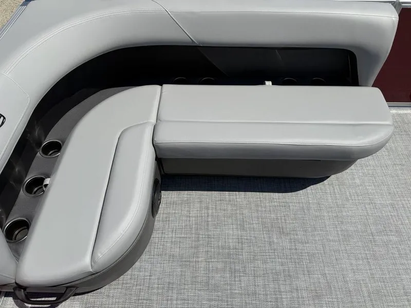 Slide: The Image of 2026 Sun Tracker PARTY BARGE® 16 DLX seating area with cup holders and gray upholstery. - 10