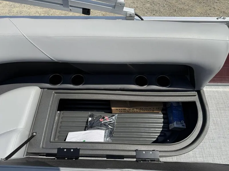 Slide: The Image of 2026 Sun Tracker PARTY BARGE® 16 DLX storage compartment with cup holders and interior items. - 12