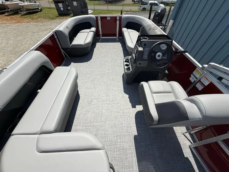 Slide: The Image of 2026 Sun Tracker PARTY BARGE® 16 DLX interior with gray seating and steering console. - 13