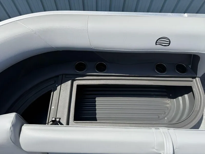 Slide: The Image of 2026 Sun Tracker PARTY BARGE® 16 DLX seating area with cup holders and storage compartment. - 2