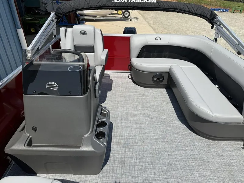 Slide: The Image of 2026 Sun Tracker PARTY BARGE® 16 DLX interior with gray seating and helm station. - 3