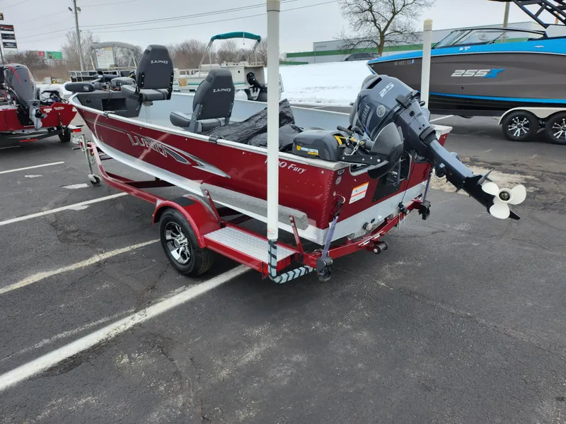 Slide: The Image of 2019 Lund 1600 Fury Tiller boat, red, parked on a trailer in a lot. - 3