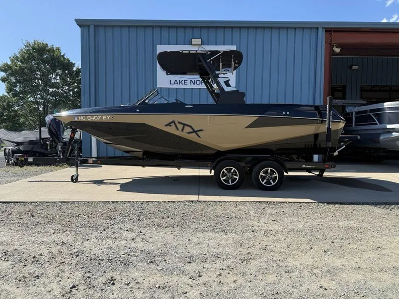 The Image of 2023 ATX Surf Boats 22 TYPE-S on trailer outside a blue building. - 0