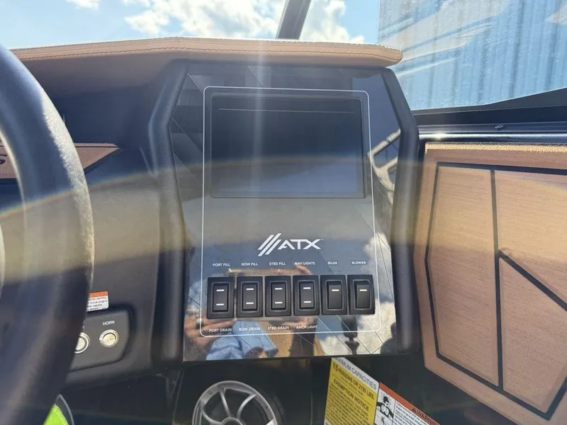 Slide: The Image of 2023 ATX Surf Boats 22 TYPE-S dashboard with control panel and switches. - 12