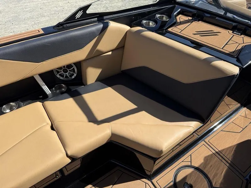 Slide: The Image of 2023 ATX Surf Boats 22 TYPE-S interior with tan and black seating, cup holders, and speaker. - 19