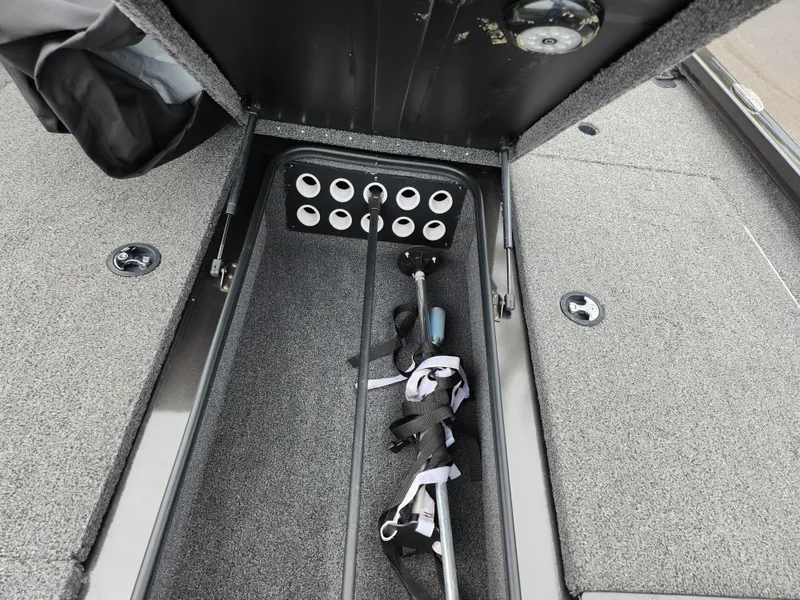 Slide: The Image of 2021 Vexus AVX189 boat storage compartment with organized rod holders and secure straps. - 15