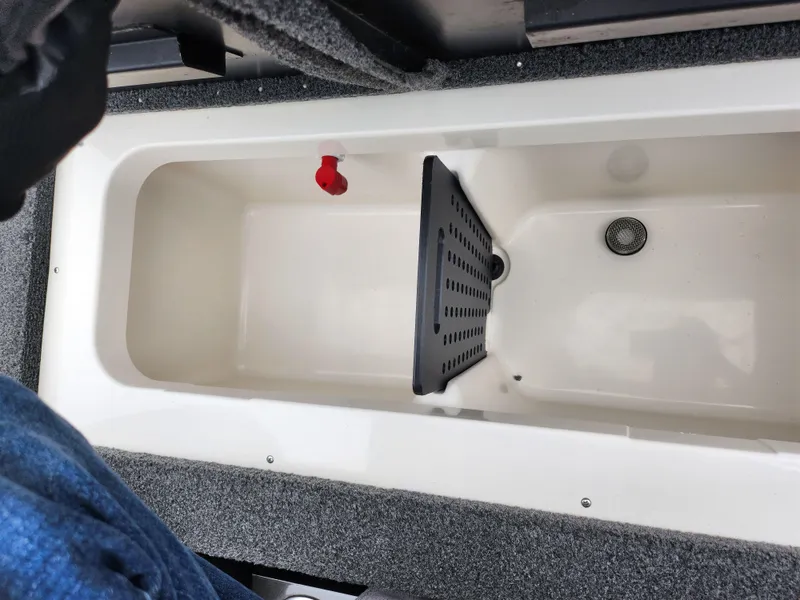 Slide: The Image of 2021 Vexus AVX189 boat livewell interior with divider and drain plug. - 23