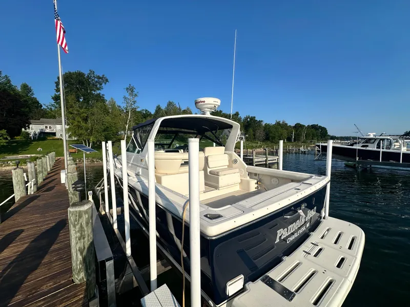 Slide: The Image of 1997 Tiara Yachts 3100 Open docked at a scenic marina under clear blue skies. - 10