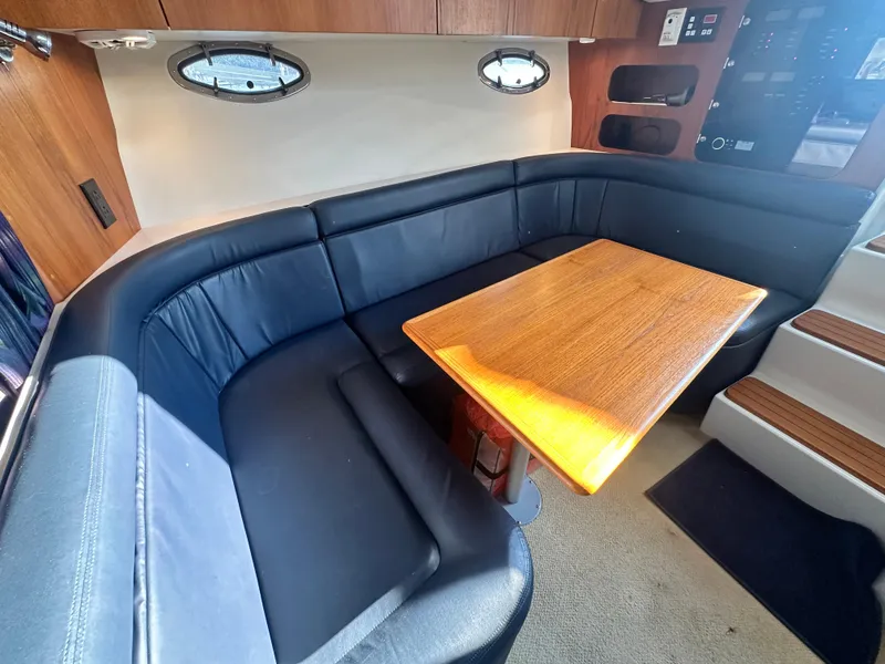 Slide: The Image of 1997 Tiara Yachts 3100 Open interior with black leather seating and wooden table. - 17