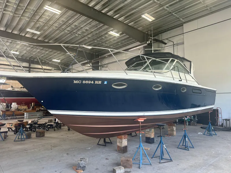 Slide: The Image of 1997 Tiara Yachts 3100 Open in a boatyard, elevated on stands. - 2