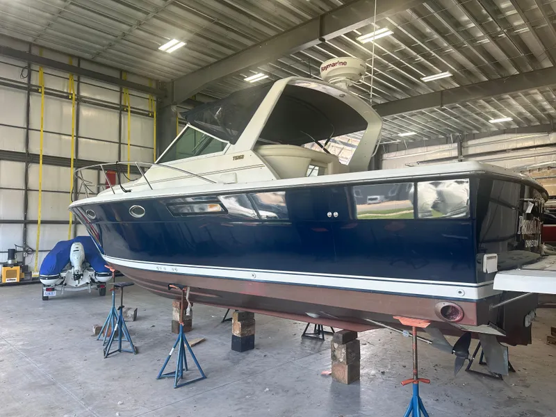 Slide: The Image of 1997 Tiara Yachts 3100 Open in a workshop, elevated on stands for maintenance. - 4