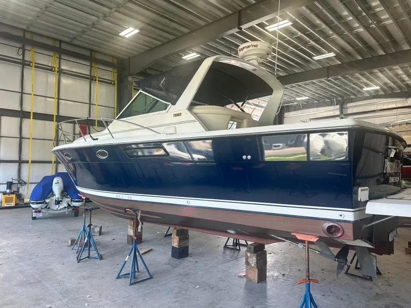 Slide: The Image of 1997 Tiara Yachts 3100 Open in a warehouse, elevated on stands for maintenance. - 5