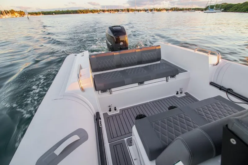Slide: The Image of 2024 Northstar Orion 8 boat interior with cushioned seating and outboard motor on water. - 12