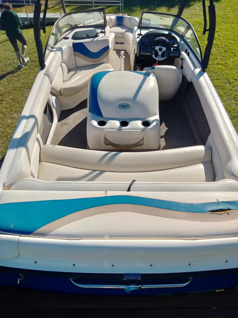 Slide: The Image of 2001 Tigé 21i boat interior with blue and white seating, steering wheel, and cup holders. - 10